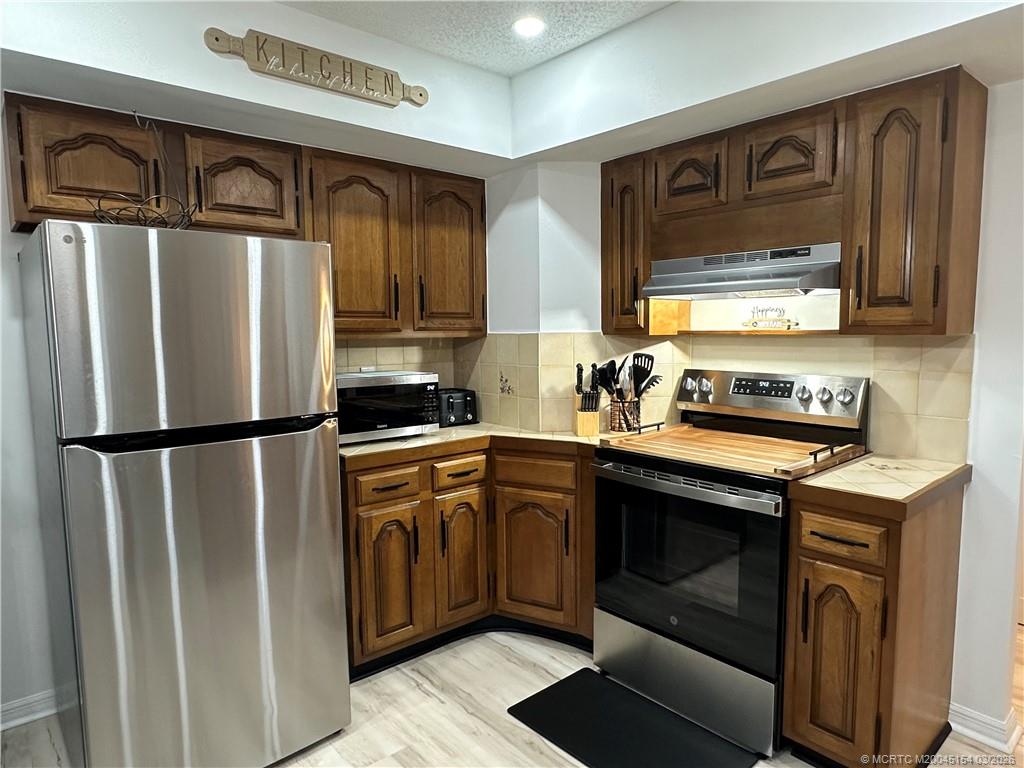 4095 Southeast Centerboard Lane, Unit 6B Stuart, FL 34997 - Photo 18 of 83 a kitchen with stainless steel appliances granite countertop a refrigerator stove and sink