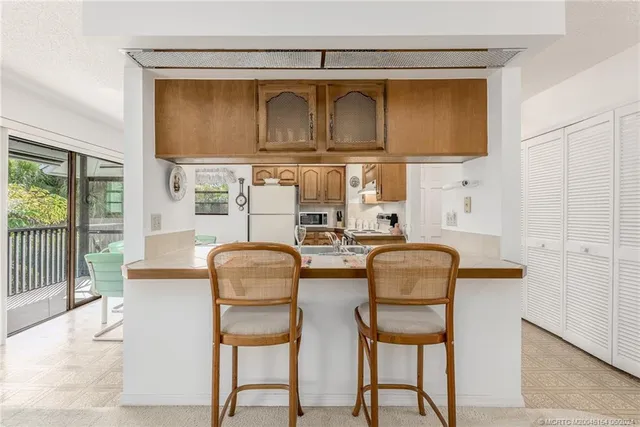 a kitchen with granite countertop a stove a sink and dishwasher with wooden floor