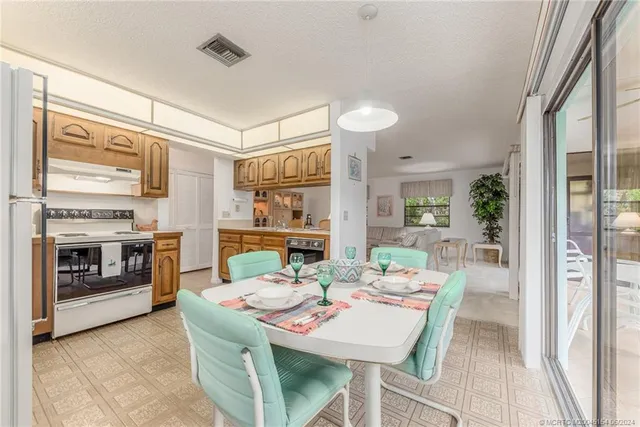 a dining room with furniture a chandelier and wooden floor