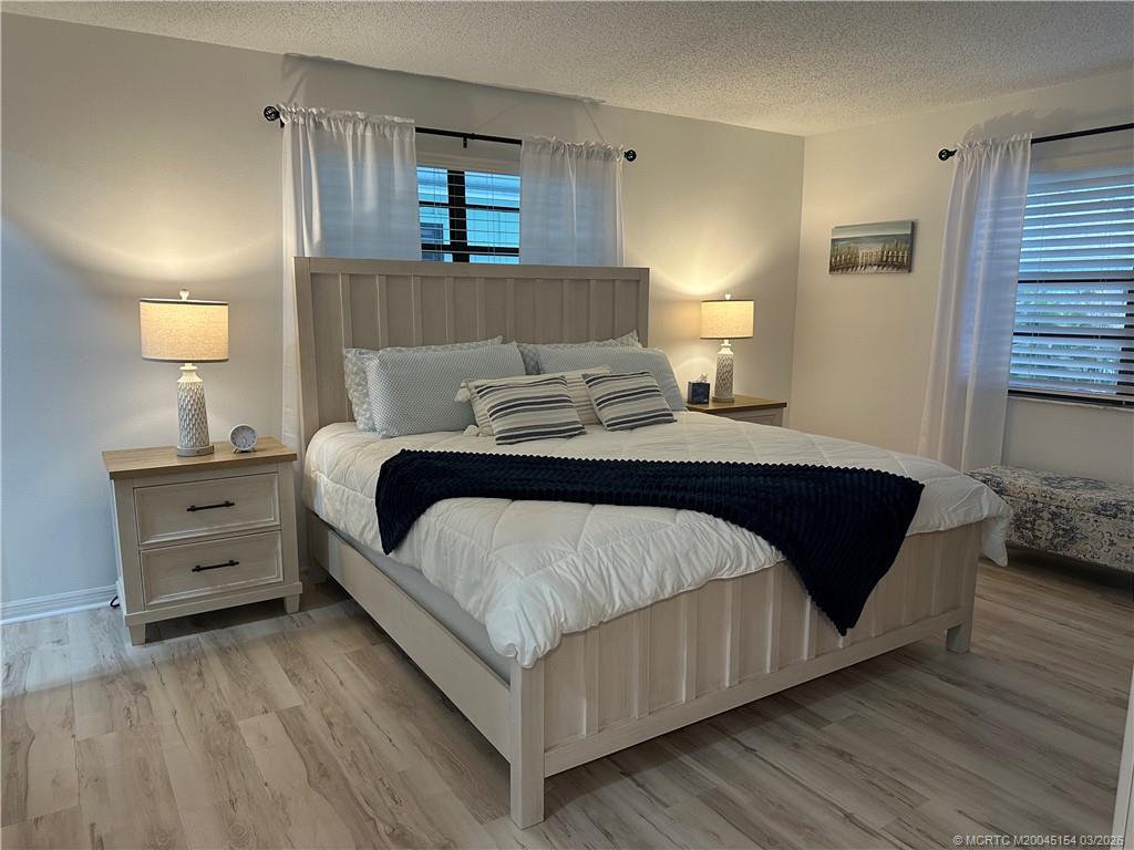 4095 Southeast Centerboard Lane, Unit 6B Stuart, FL 34997 - Photo 28 of 83 a bedroom with a bed and wooden floor