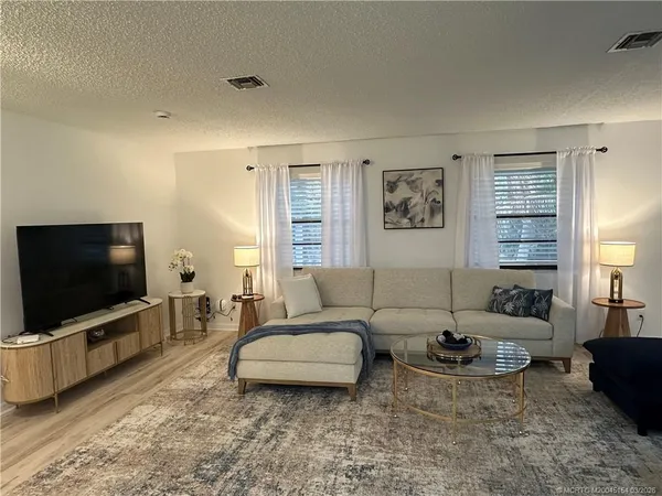 a bedroom with a bed a flat screen tv and a couch