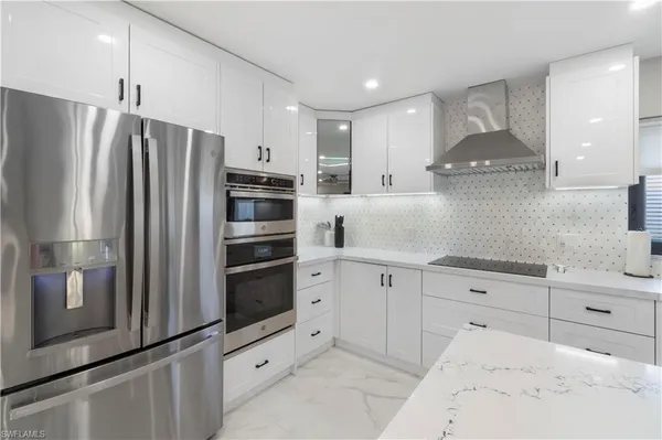a kitchen with stainless steel appliances kitchen island granite countertop a refrigerator and a stove