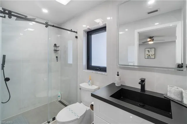 a bathroom with a sink a toilet and shower