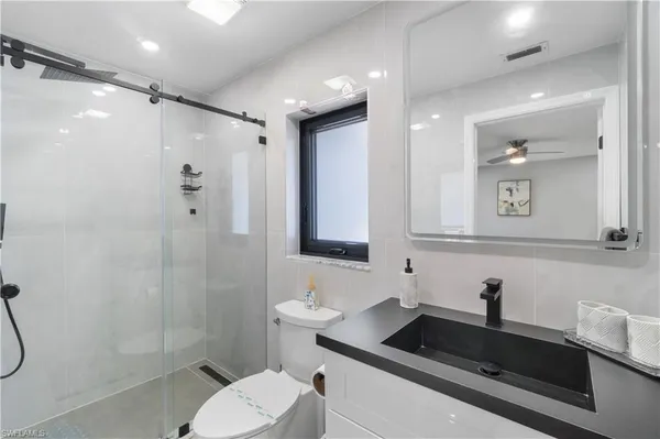 a bathroom with a sink a toilet and shower