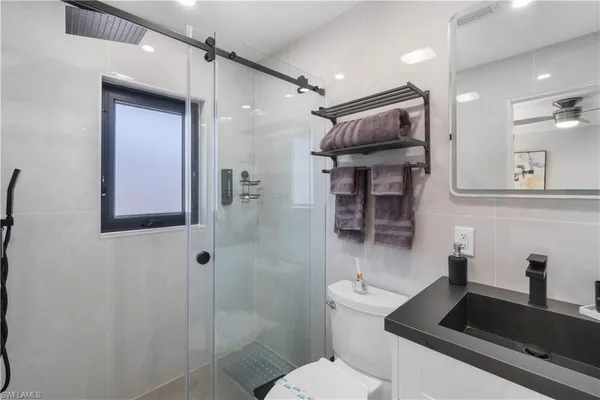 a bathroom with a sink a toilet and shower