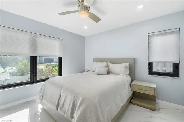 a large white bed in a room next to a window