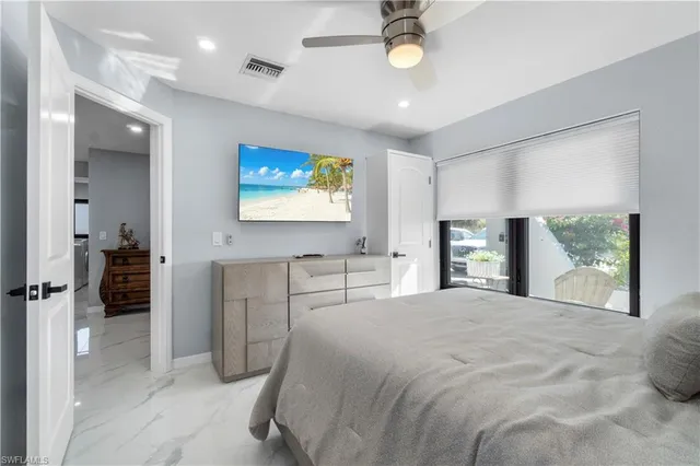 a bedroom with a balcony a bed and a flat screen tv