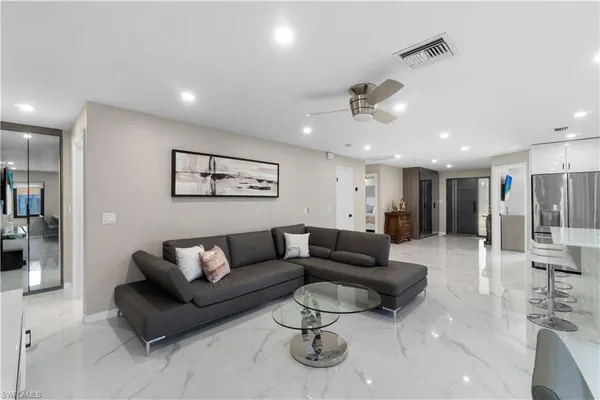 a living room with furniture and a ceiling fan