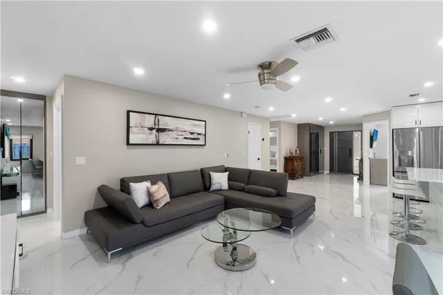 a living room with furniture and a ceiling fan