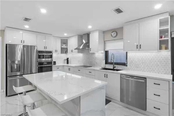 a large kitchen with stainless steel appliances and a refrigerator