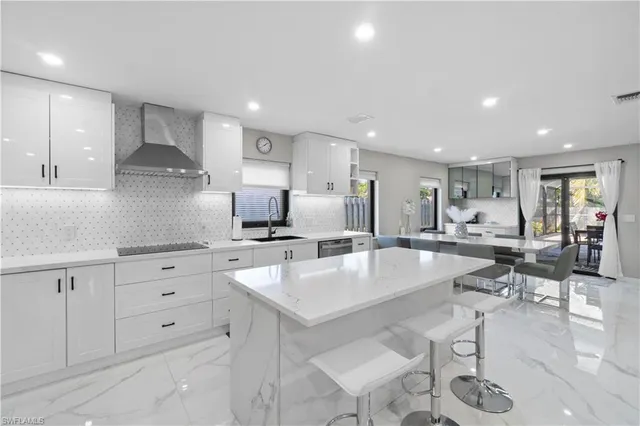 a large white kitchen with lots of counter space wooden floor and appliances