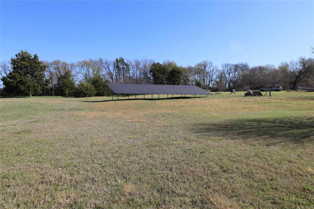 907 Red Oak Creek Road Ovilla, TX 75154 - Photo 2 of 20 Expansive open field featuring a large ground-mounted solar panel array