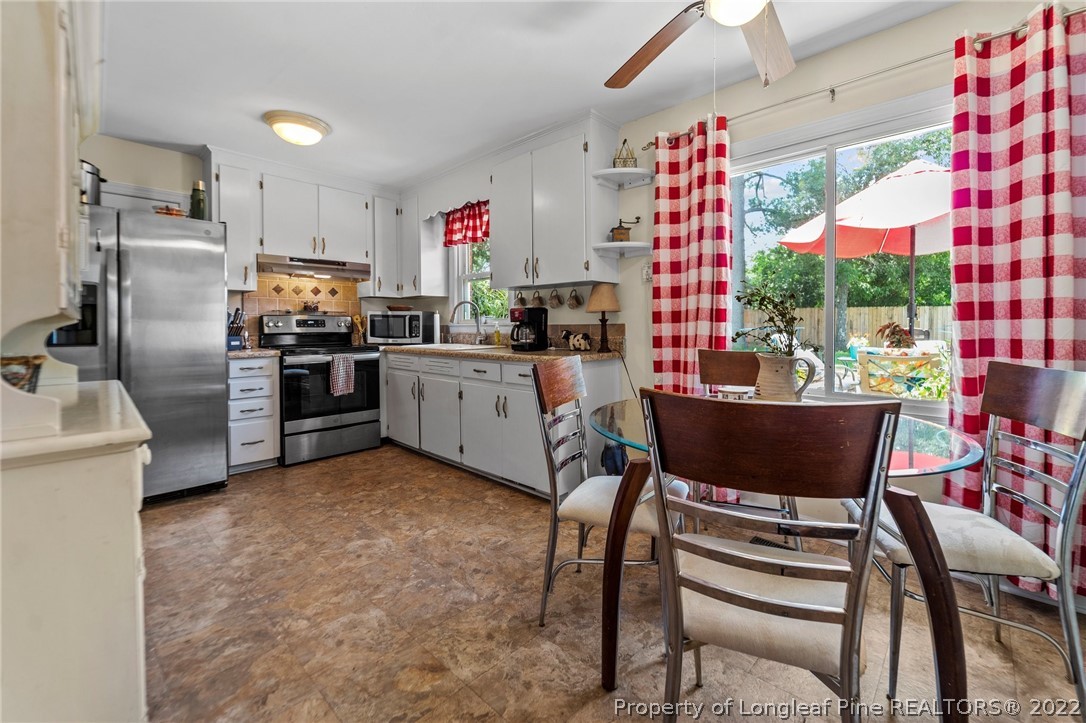 1103 Vass Road Spring Lake, NC 28390 - Photo 29 of 37 a kitchen with stainless steel appliances kitchen island granite countertop a table and chairs in it
