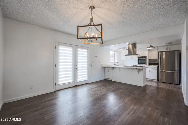 a view of a kitchen with wooden floor stainless steel appliances and cabinets