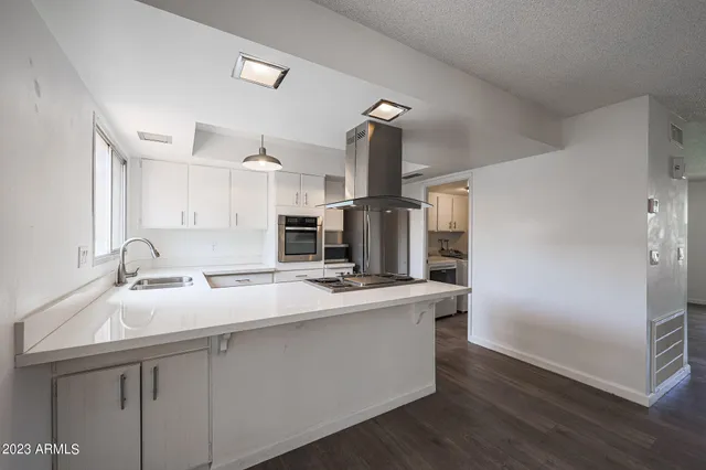 a kitchen with kitchen island a sink appliances and cabinets