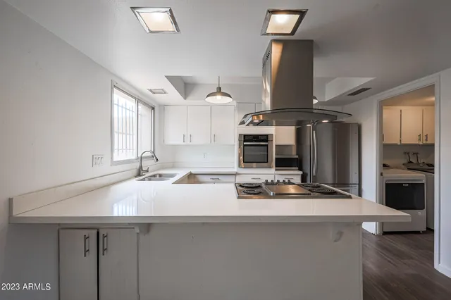 a kitchen with kitchen island a sink appliances and cabinets
