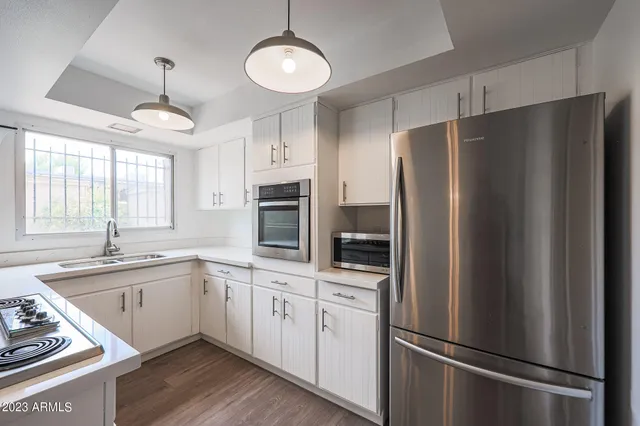 a kitchen with white cabinets and stainless steel appliances