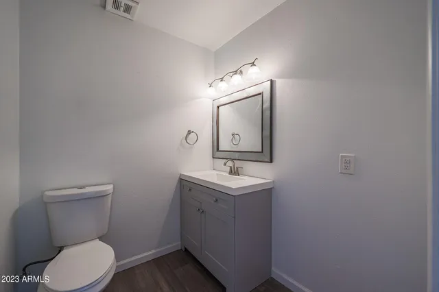 a bathroom with a toilet a sink and mirror