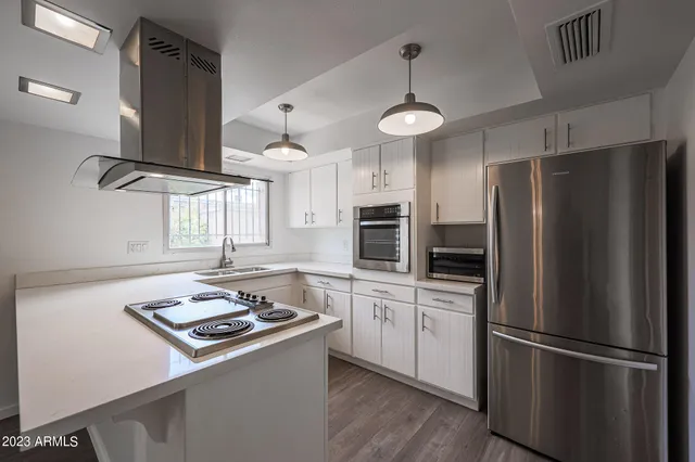 a kitchen with stainless steel appliances a refrigerator a sink and a stove