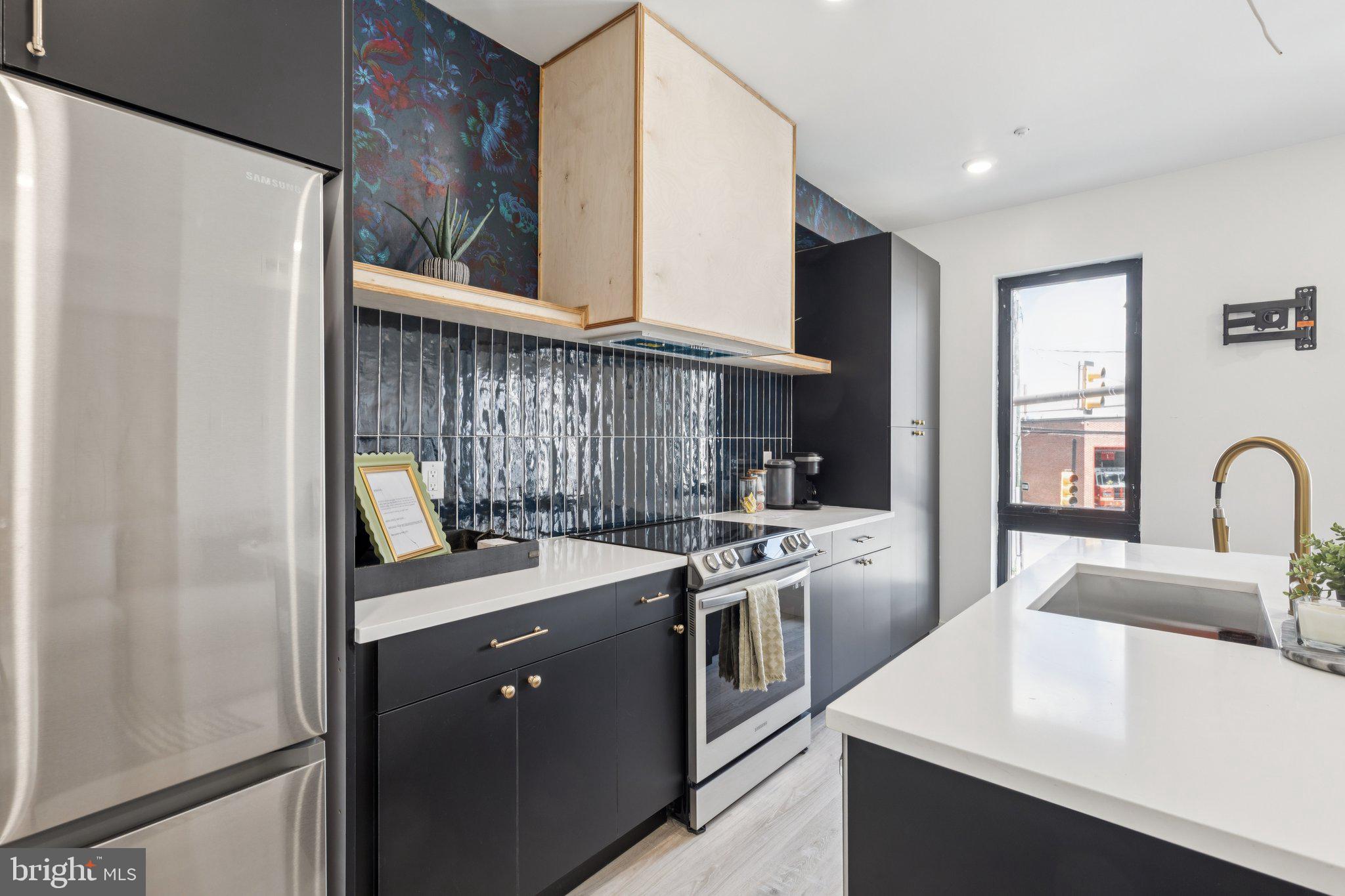 1602 Ridge Avenue, Unit 2 Philadelphia, PA 19130 - Photo 7 of 17 a kitchen with stainless steel appliances granite countertop a sink stove and refrigerator