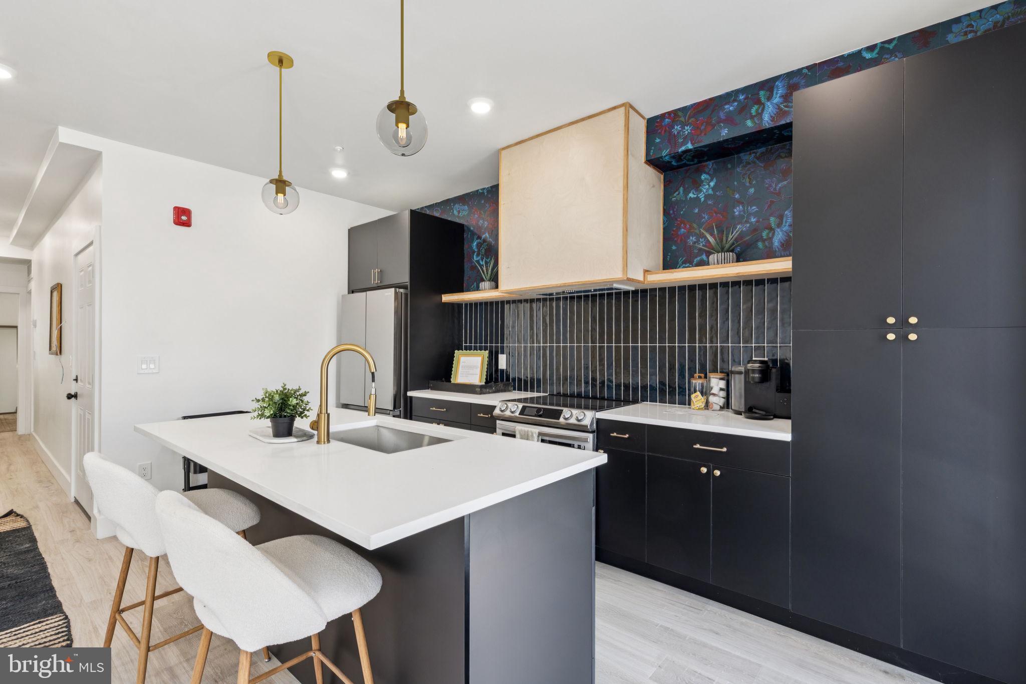1602 Ridge Avenue, Unit 2 Philadelphia, PA 19130 - Photo 8 of 17 a kitchen with a sink a stove a refrigerator and chairs