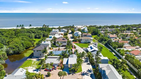 an aerial view of residential houses with outdoor space and trees