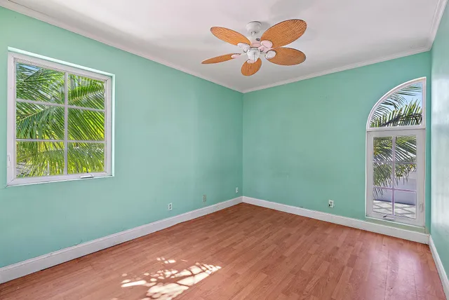 an empty room with window and wooden floor