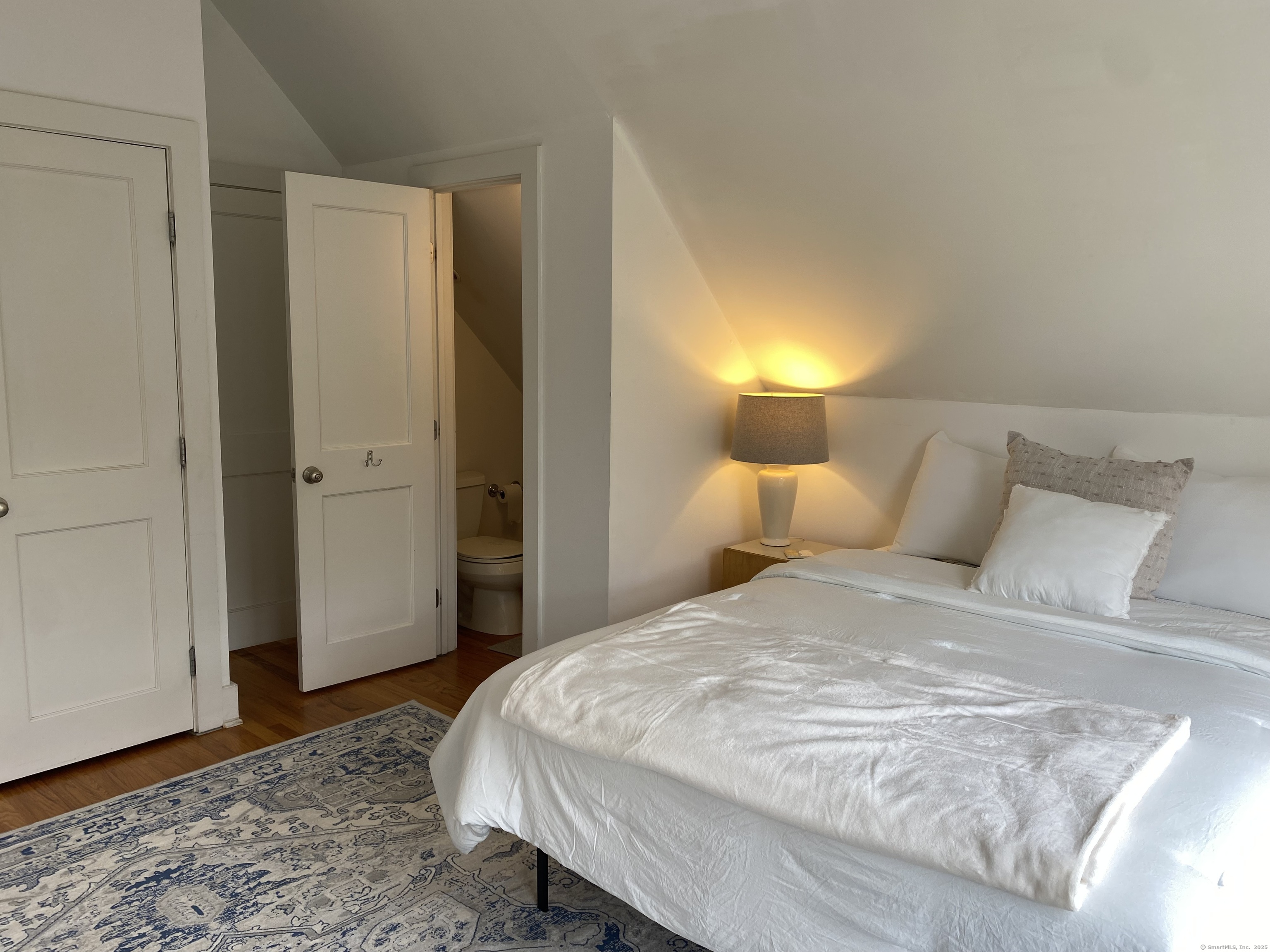 33 Copse Road, Unit B Madison, CT 06443 - Photo 11 of 16 a bedroom with a bed and wooden floor