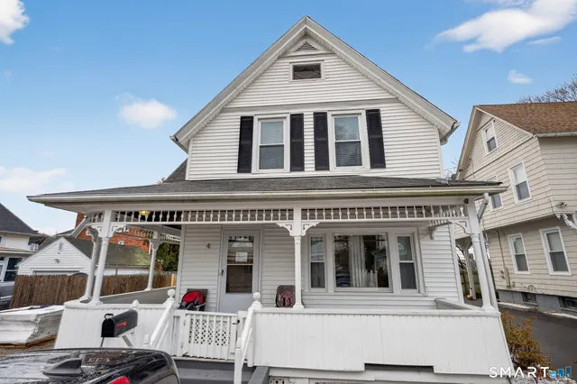 a view of a white house with large windows and refrigerator