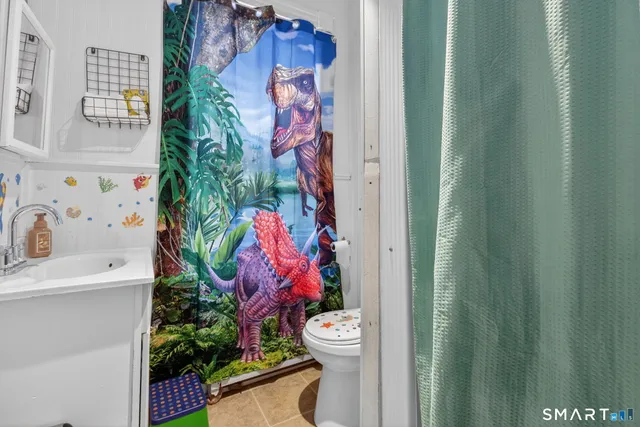 a bathroom with a toilet and a shower curtain