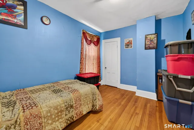a bedroom with a bed and wooden floor