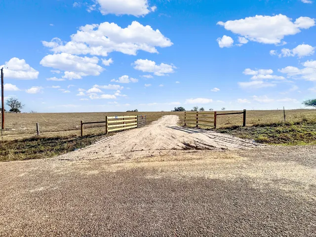 a view of a dry yard with wooden fence