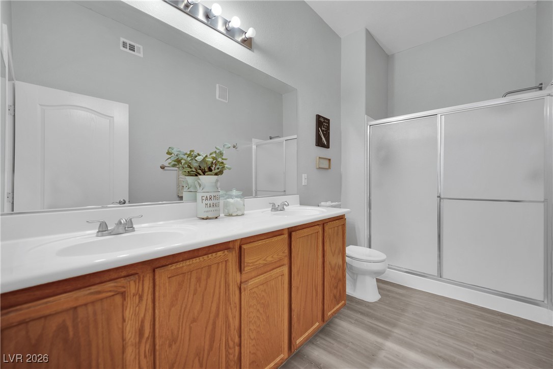3544 Desert Cliff Street, Unit 101 Las Vegas, NV 89129 - Photo 7 of 29 Bathroom with double vanity, a shower stall, and light wood-style flooring
