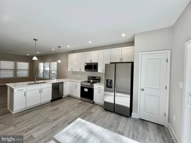 a view of a room with wooden floors and white walls