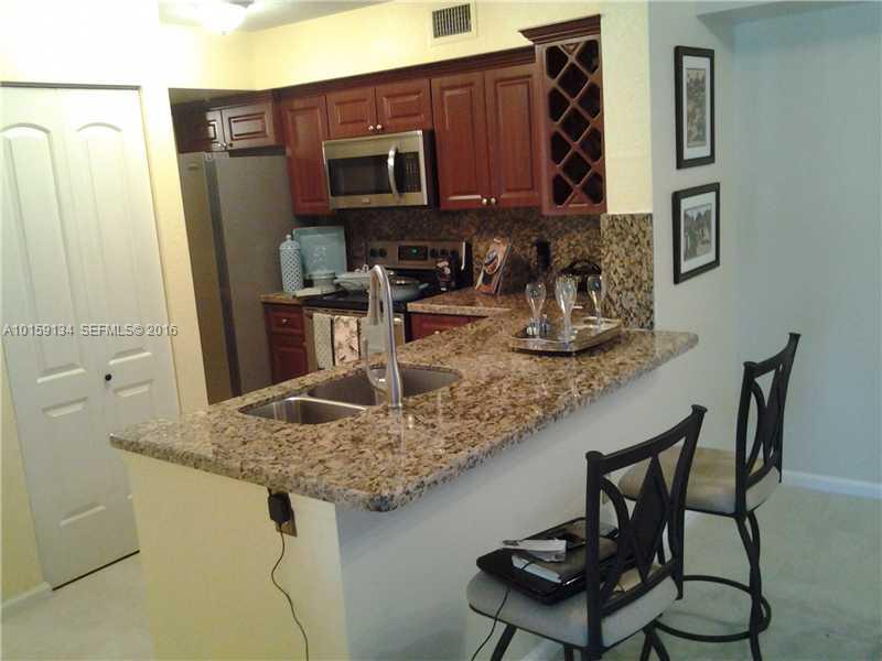 15480 Southwest 284th Street, Unit 2207 Homestead, FL 33033 - Photo 3 of 12 a kitchen with stainless steel appliances granite countertop a sink refrigerator and microwave