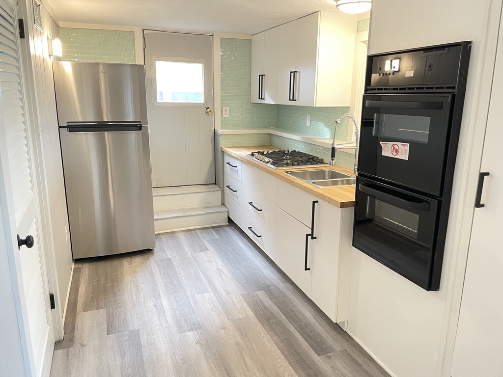 85 Regatta Road Weymouth, MA 02191 - Photo 15 of 33 a kitchen with a refrigerator a stove and white cabinets