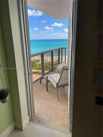 a living room with a chair and floor to ceiling window
