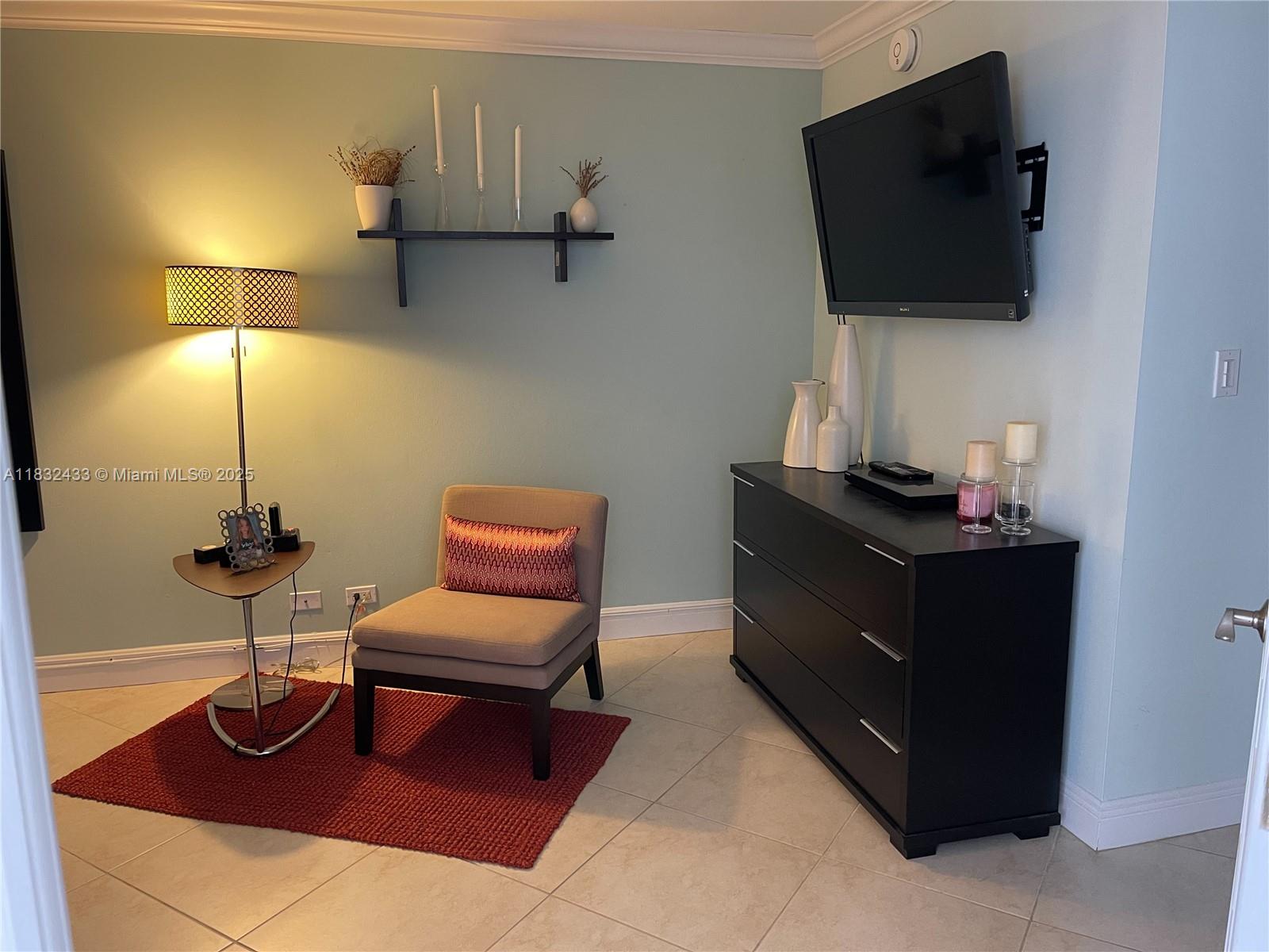 6039 Collins Avenue, Unit 823 Miami Beach, FL 33140 - Photo 12 of 21 a living room with furniture and a flat screen tv