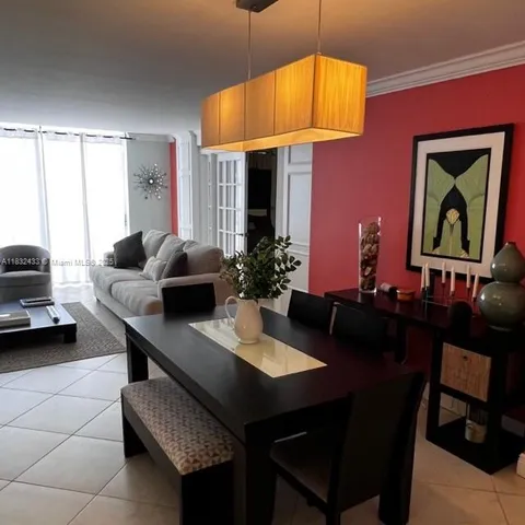 a dining room with furniture and a chandelier
