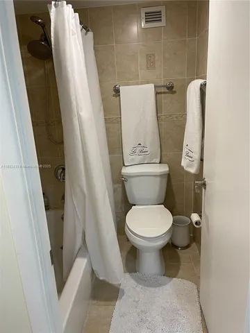 a white toilet sitting next to a sink