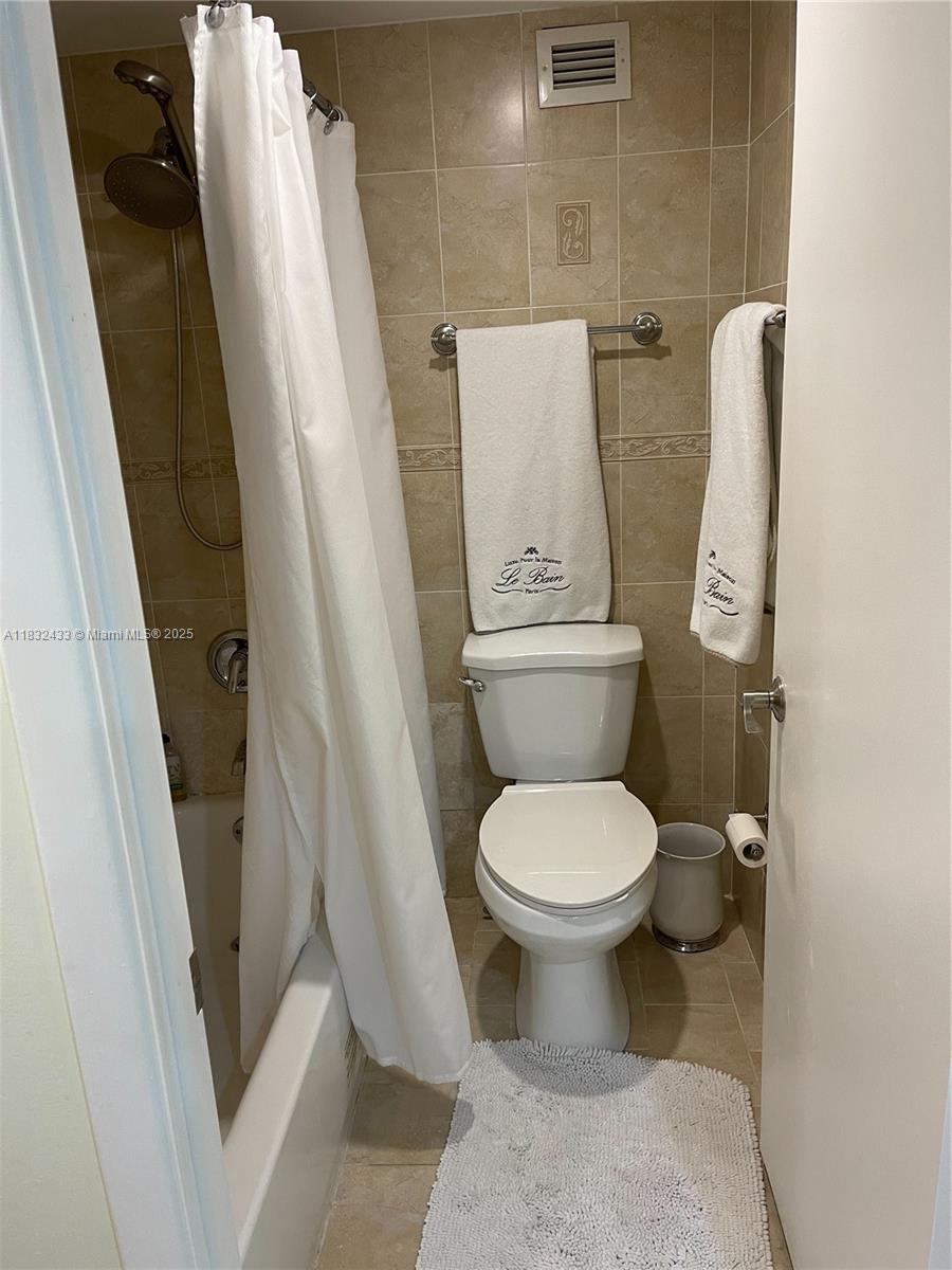 6039 Collins Avenue, Unit 823 Miami Beach, FL 33140 - Photo 10 of 21 a white toilet sitting next to a sink