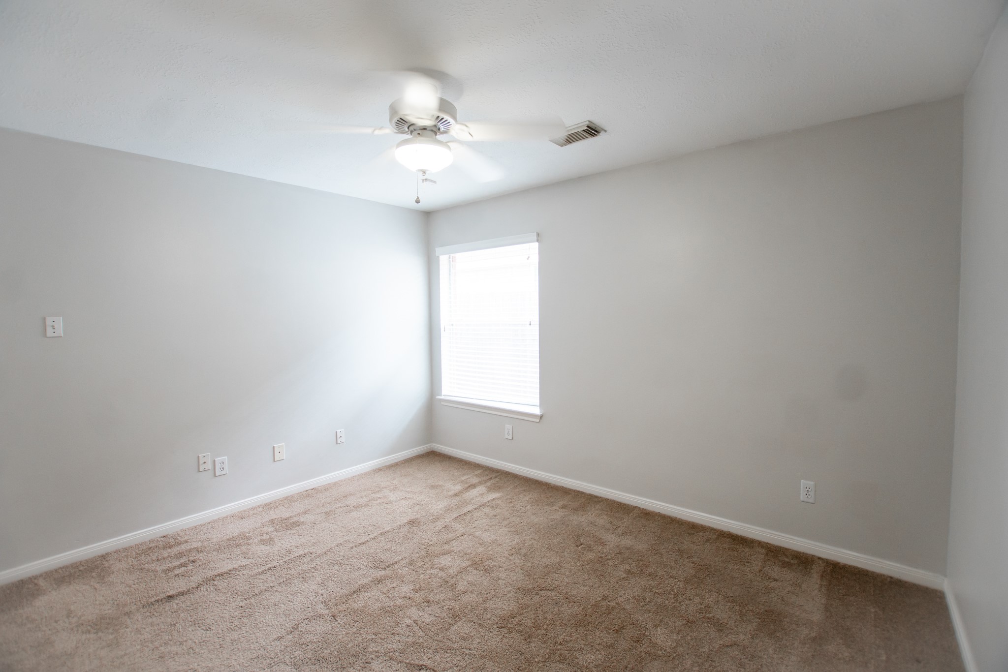 1722 Red Oak Terrace Houston, TX 77339 - Photo 9 of 22 an empty room with a chandelier fan and windows