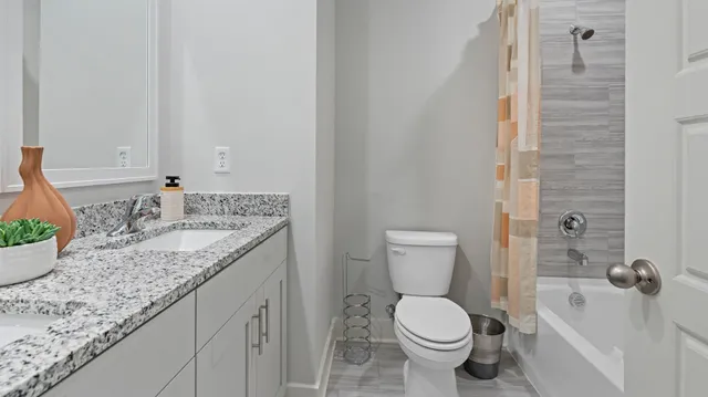 a bathroom with a granite countertop toilet and a sink