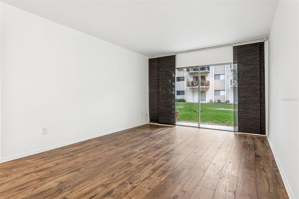 4606 West Gray Street, Unit 105 Tampa, FL 33609 - Photo 11 of 25 a view of an empty room with a window and wooden floor