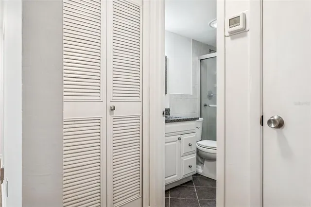 a bathroom with a granite countertop sink a toilet and shower