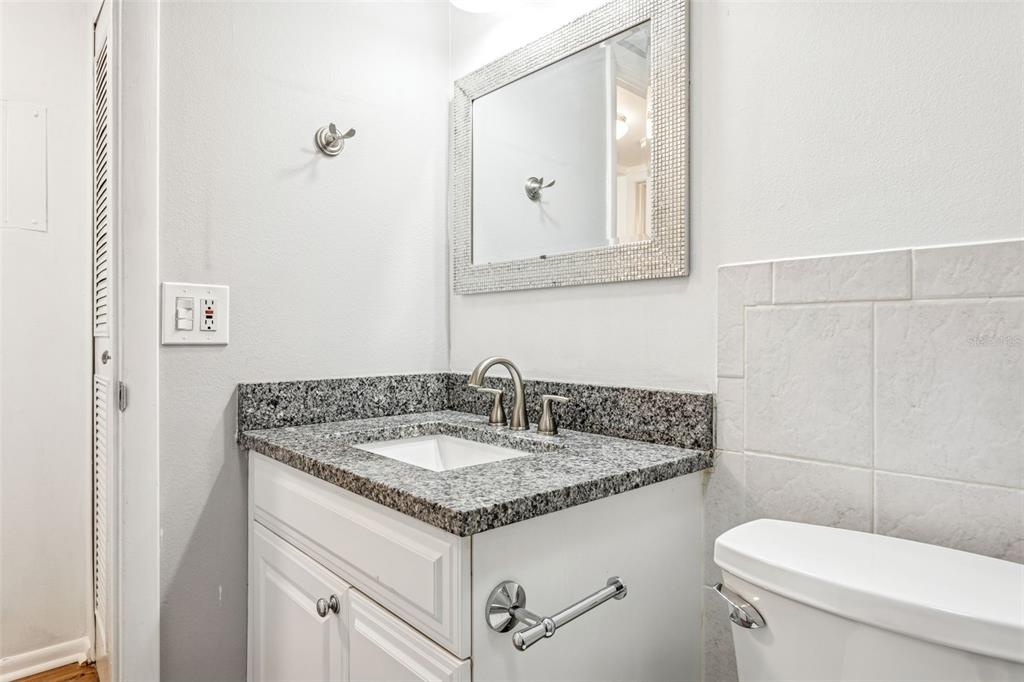 4606 West Gray Street, Unit 105 Tampa, FL 33609 - Photo 15 of 25 a bathroom with a granite countertop sink and a toilet