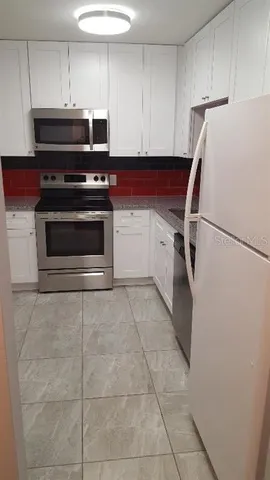 a kitchen with cabinets and steel appliances