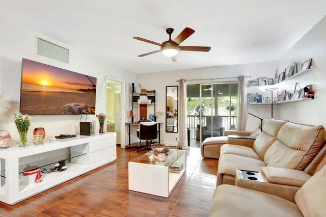 a living room with furniture kitchen view and a flat screen tv