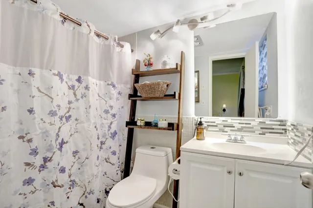 a bathroom with a toilet sink and mirror