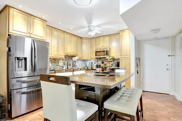 a kitchen with stainless steel appliances granite countertop a refrigerator a stove a sink and a refrigerator